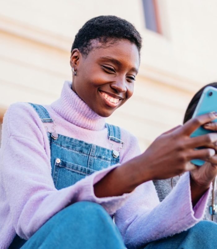 young-happy-african-american-woman-using-smartphone-sharing-media-with-friends-with-new-app-.jpg